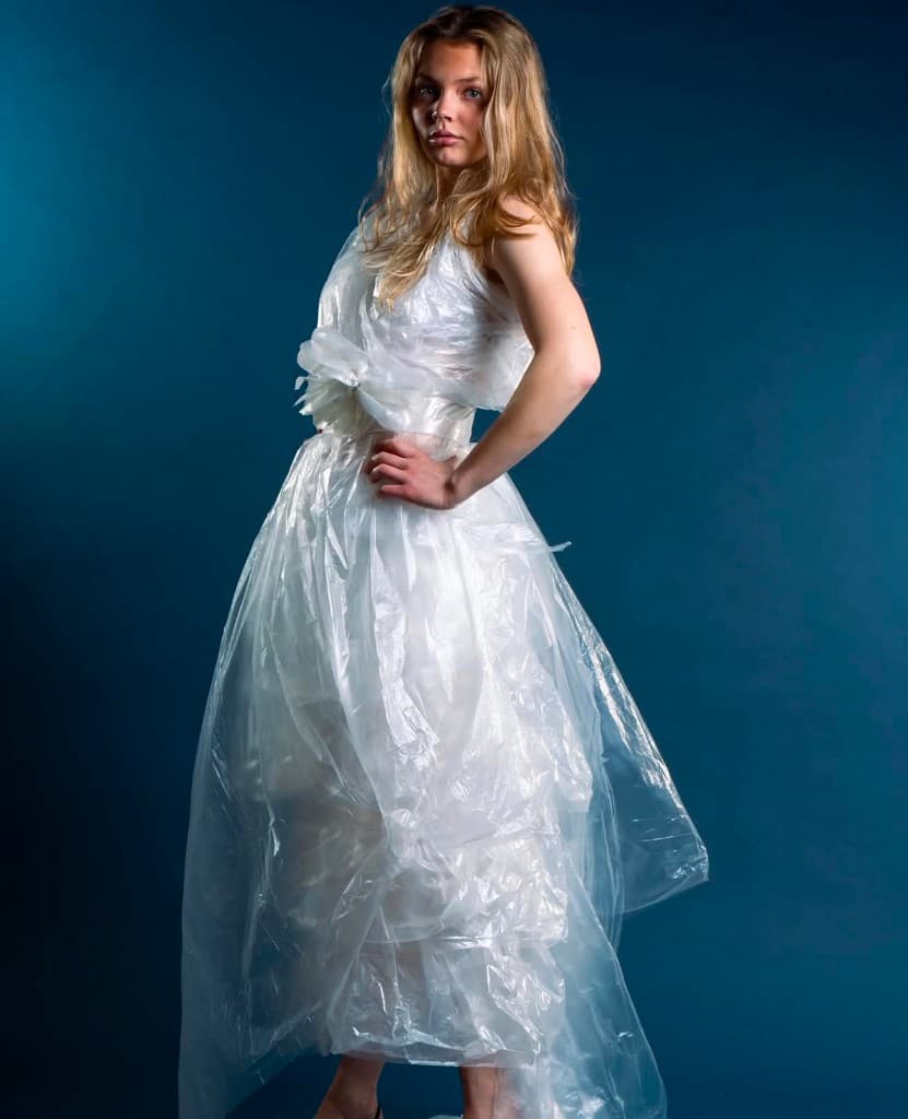 Editorial studio portrett — full figur i hvit kjole mot mørk teal-blå bakgrunn, fotografert av Emma Hansen